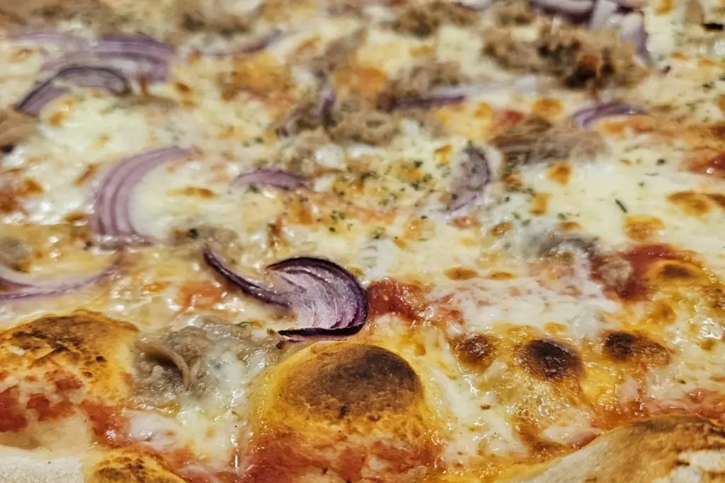 Pizza mit Thunfisch und roten Zwiebeln vom Lieferdienst Toscana in Minden